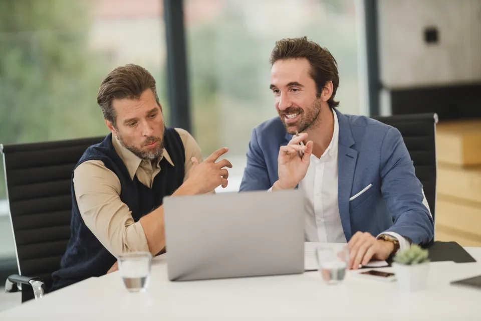 Deux professionnels échangeant devant un ordinateur portable