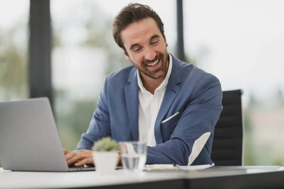 Chef d’entreprise souriant travaillant sur son ordinateur portable